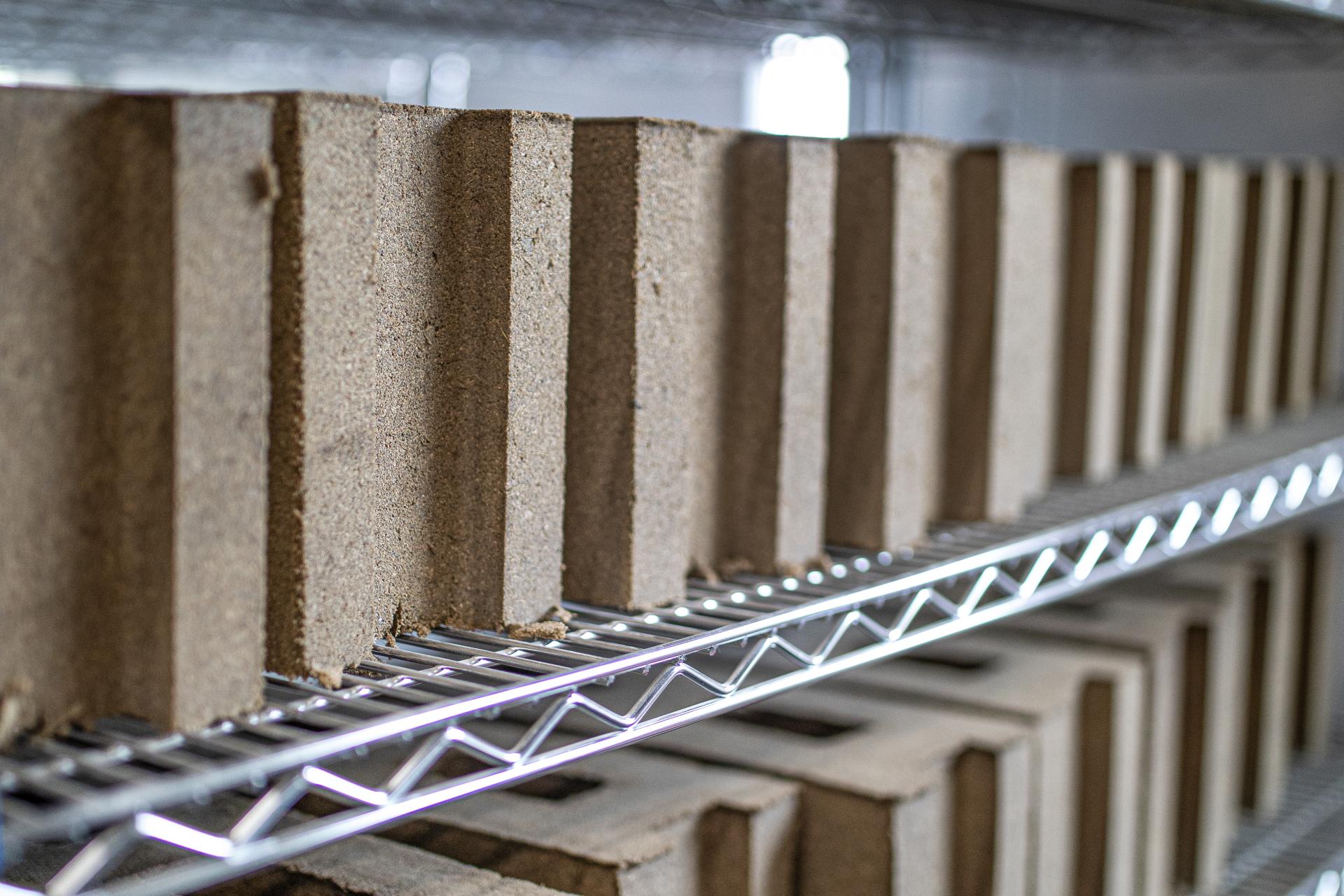 Sustainable building materials stacked on shelves, showcasing Prometheus Materials' eco-friendly products for zero-carbon construction.