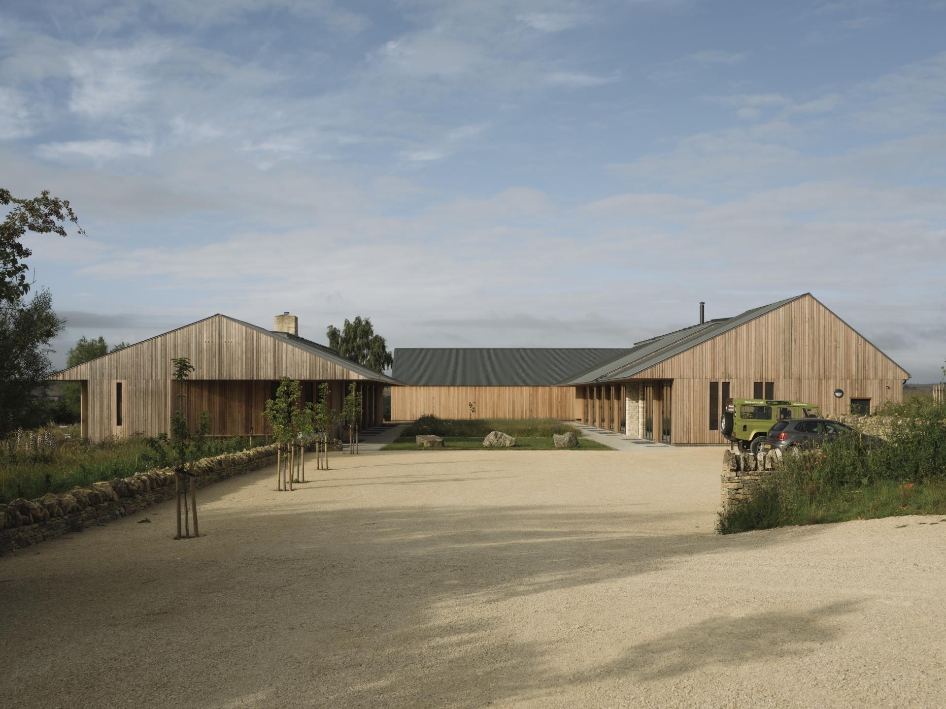 Sustainable farming education centre designed by Timothy Tasker Architects, featuring natural wood architecture and landscaped surroundings.
