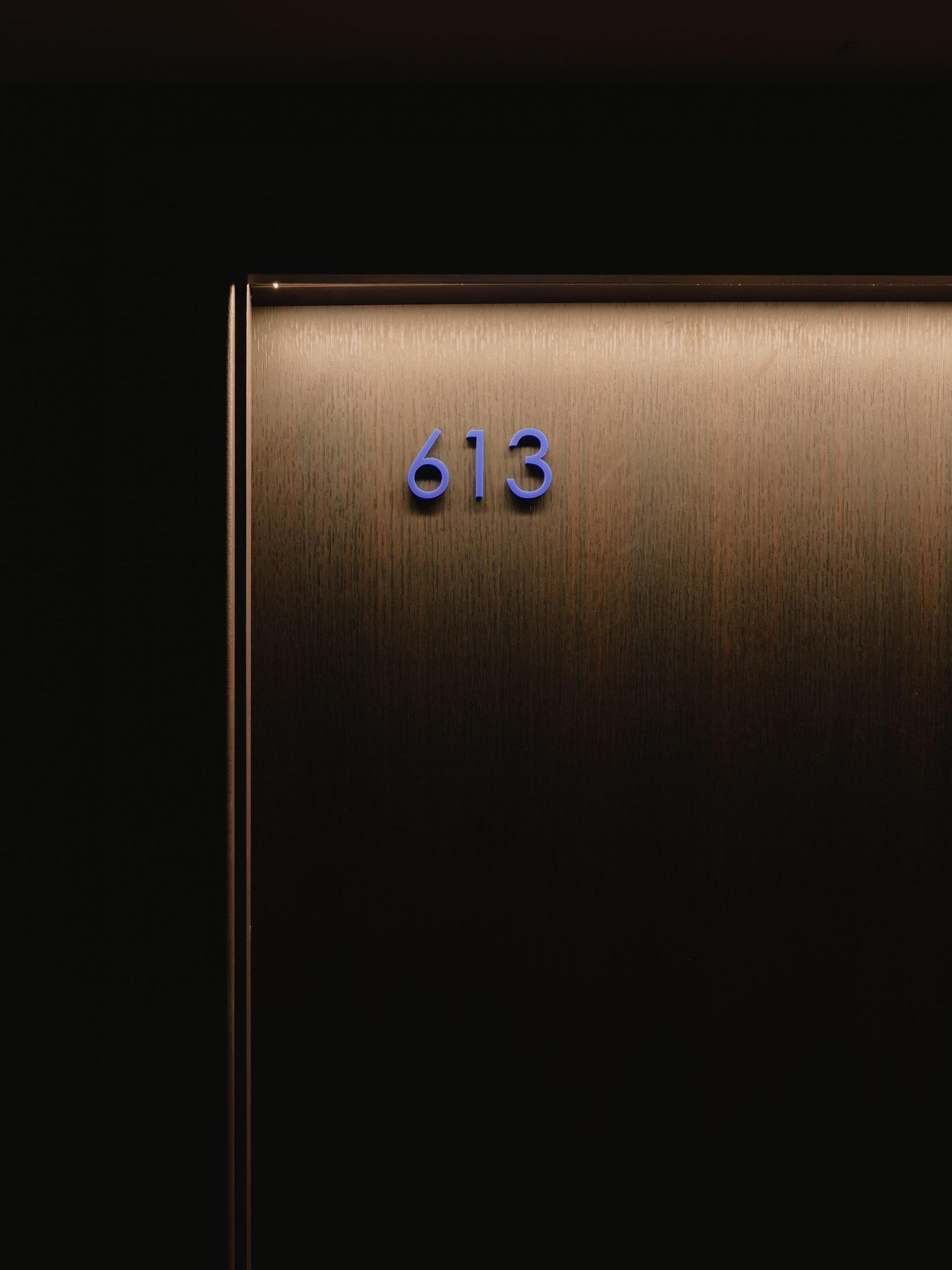 Modern door number 613 in atmospheric interior of PBSA at 16-18 Potterrow, Edinburgh, designed by Jasper Sanders + Partners.