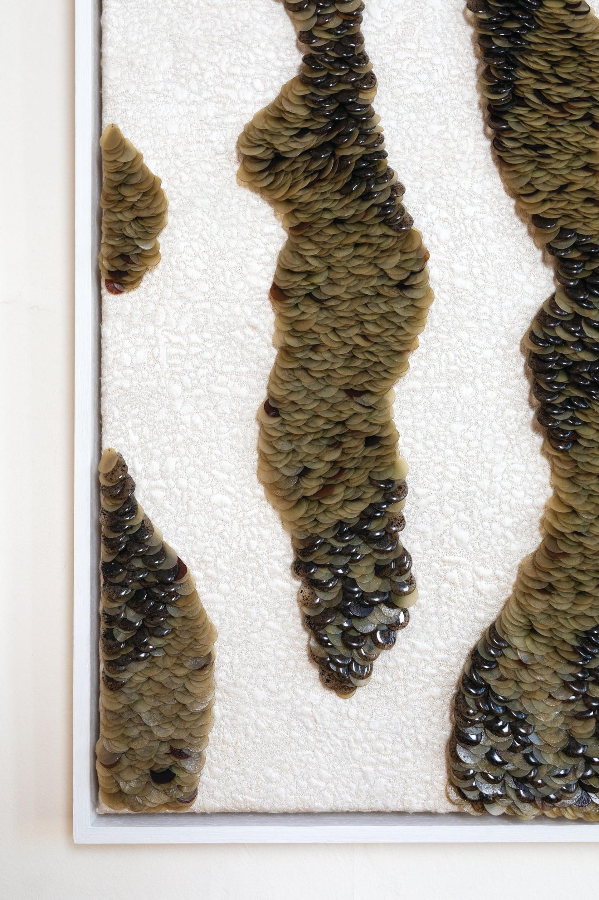 Textile art piece created with Scottish seaweed, showcasing intricate layered patterns on a textured fabric background.