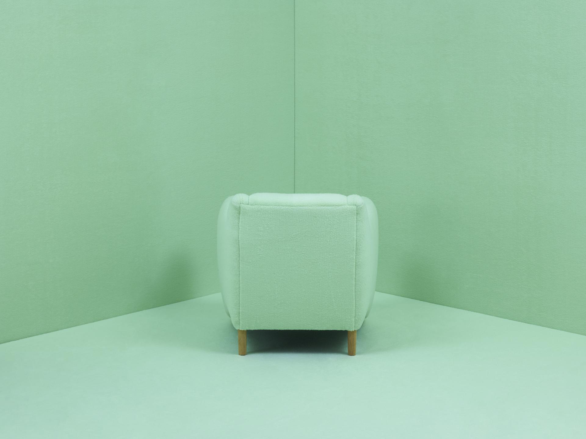 Matthew Hilton's Balzac armchair features a soft green fabric and elegant wooden legs, celebrating 30 years of design excellence.