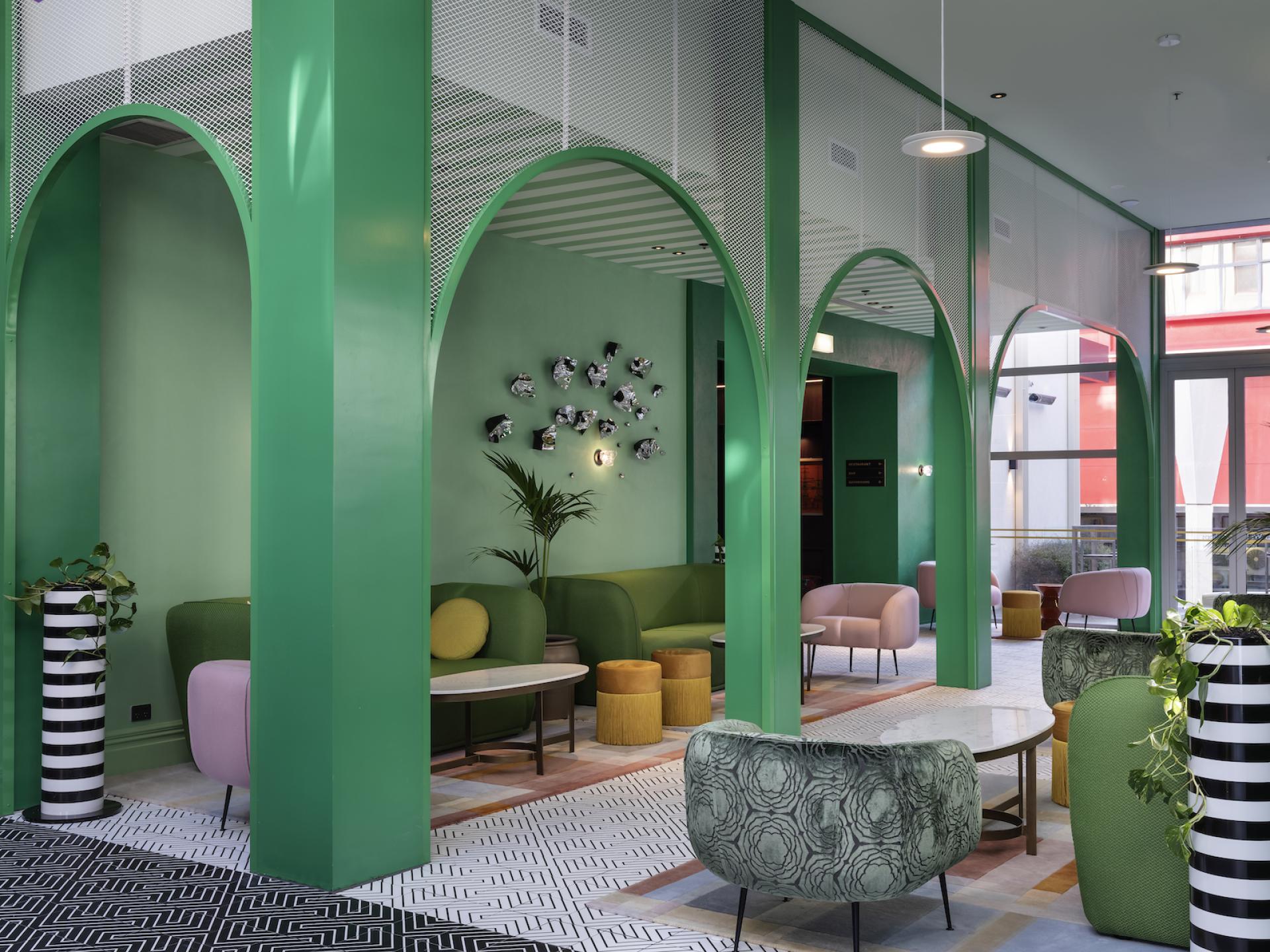 Vibrant interior of Naumi Studio Hotel featuring colour blocking, neon accents, and botanical decor in Wellington.