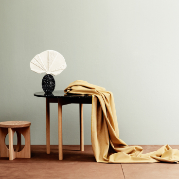 Contemporary furniture display featuring a draped fabric and artistic decor, highlighting Norway's focus on sustainability and design.