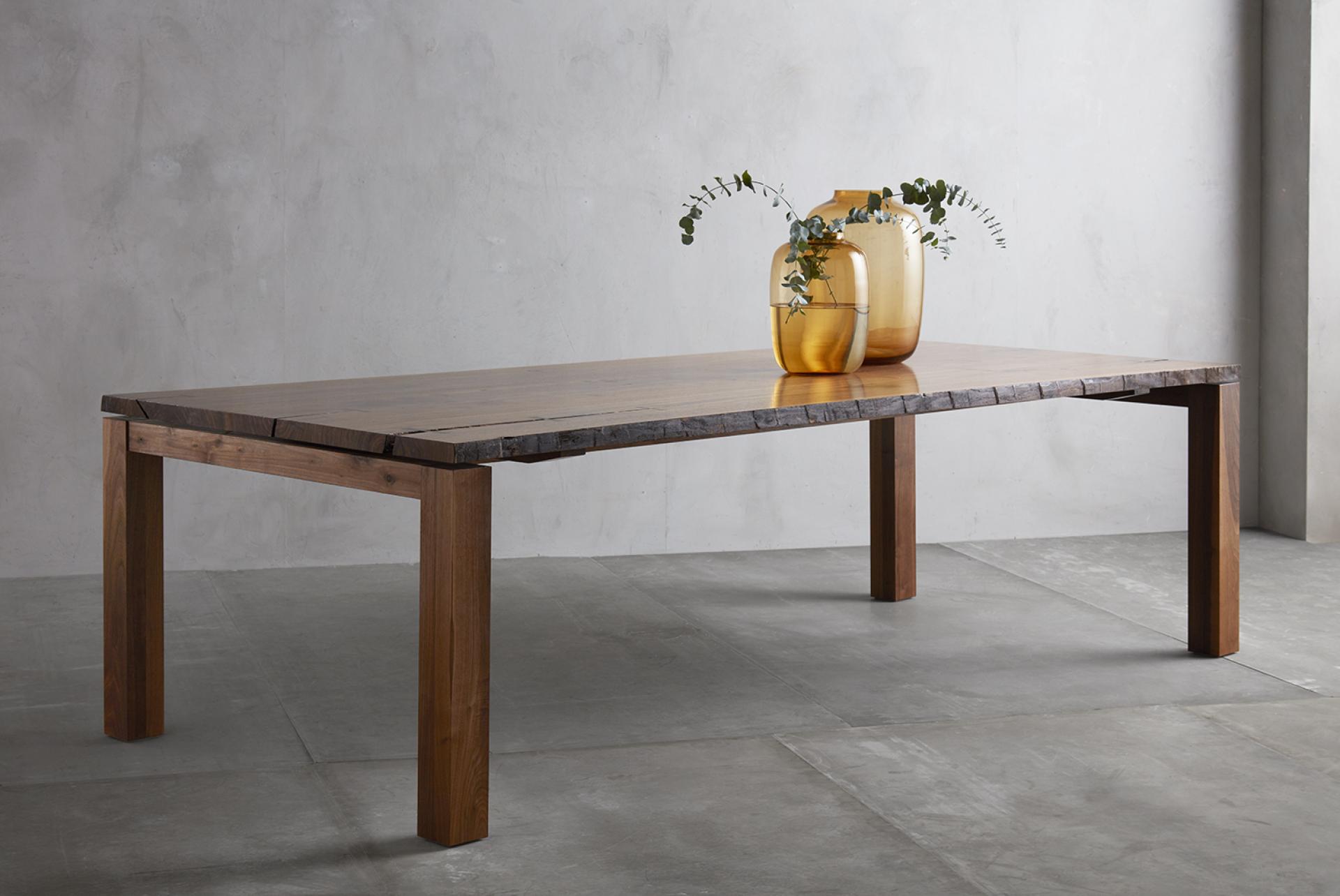 Elegant wooden dining table with unique edge detail, adorned with stylish vases, reflecting Japanese woodwork artistry.