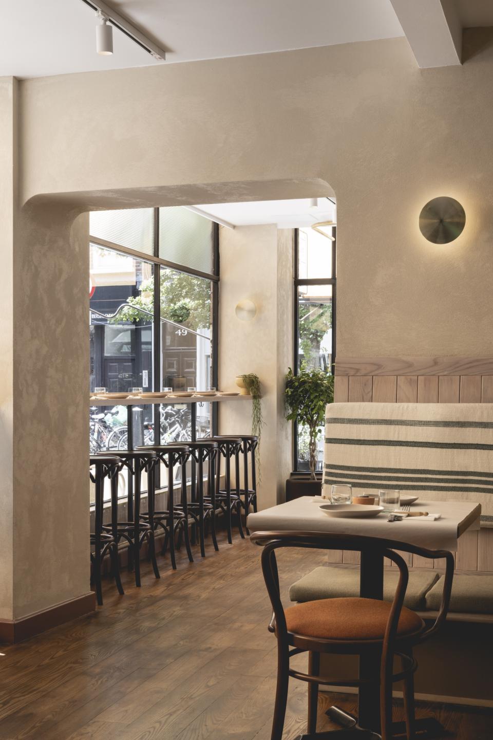 Warm, inviting interior of Honey & Co restaurant in Bloomsbury, featuring wood accents and natural light.