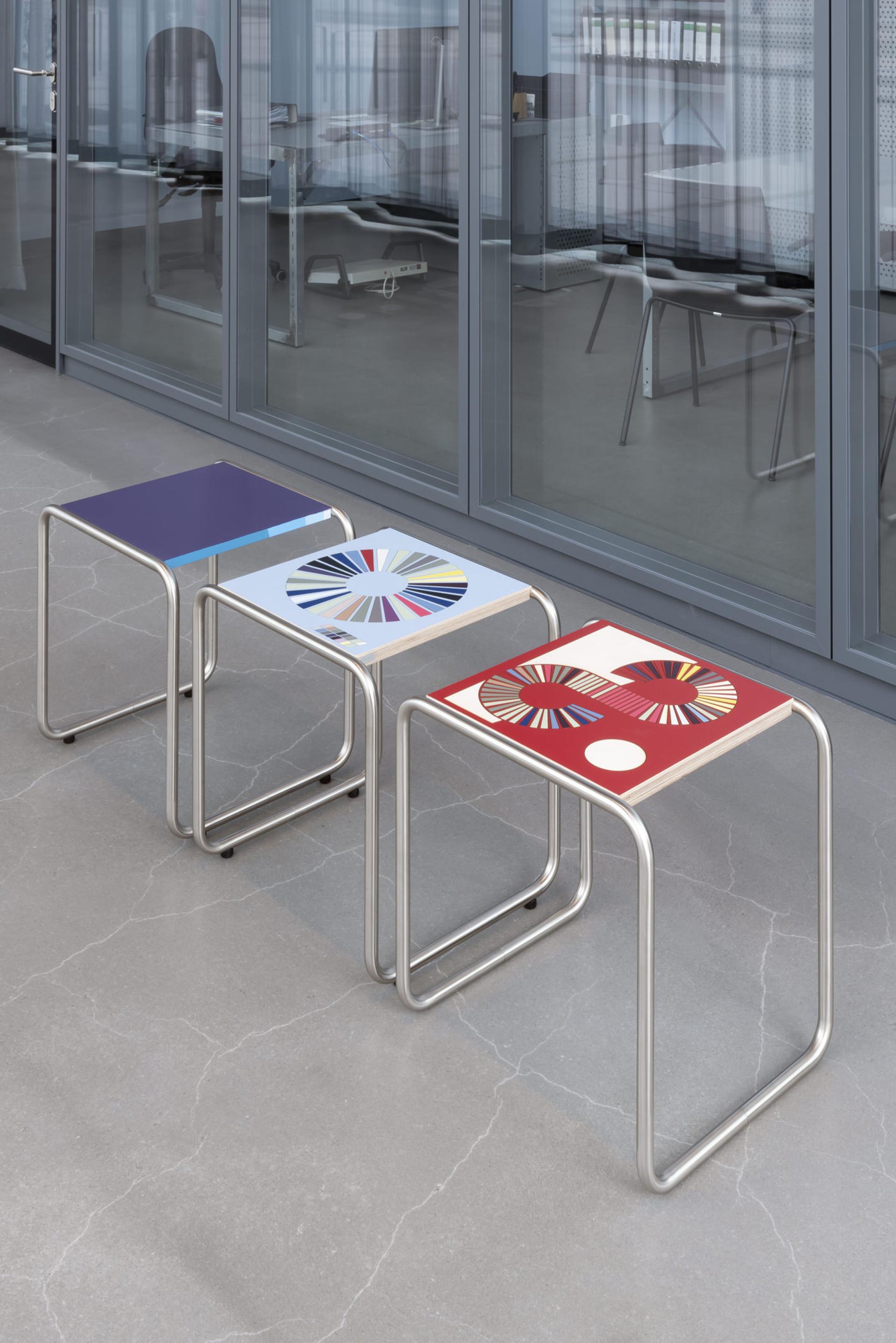 Three limited edition B 9 tubular steel stools by Jay Gard, featuring colorful designs, displayed in the Bauhaus Museum Dessau.