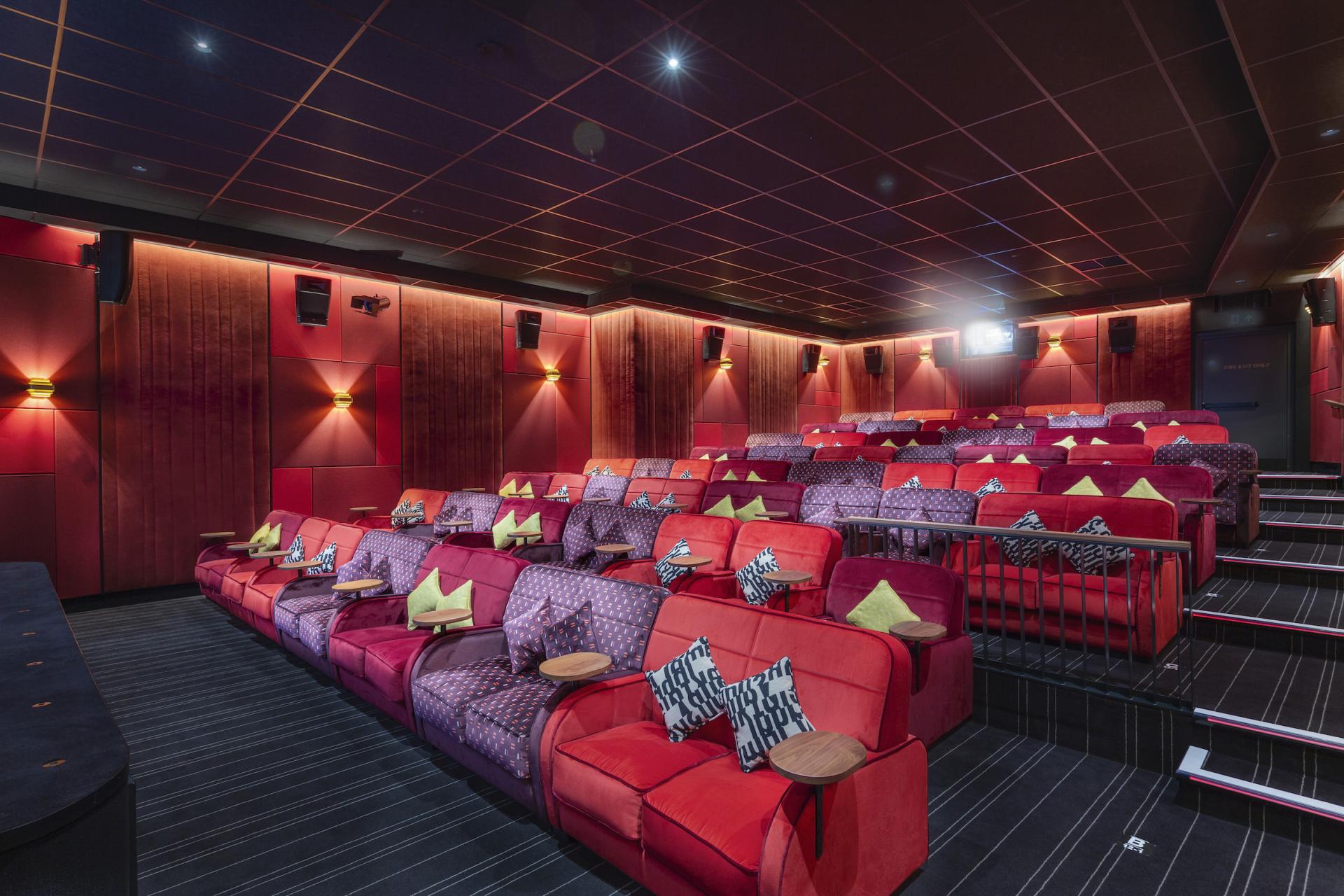 Luxurious cinema seating in a modern theater, highlighting the link between acoustics and audience wellbeing.