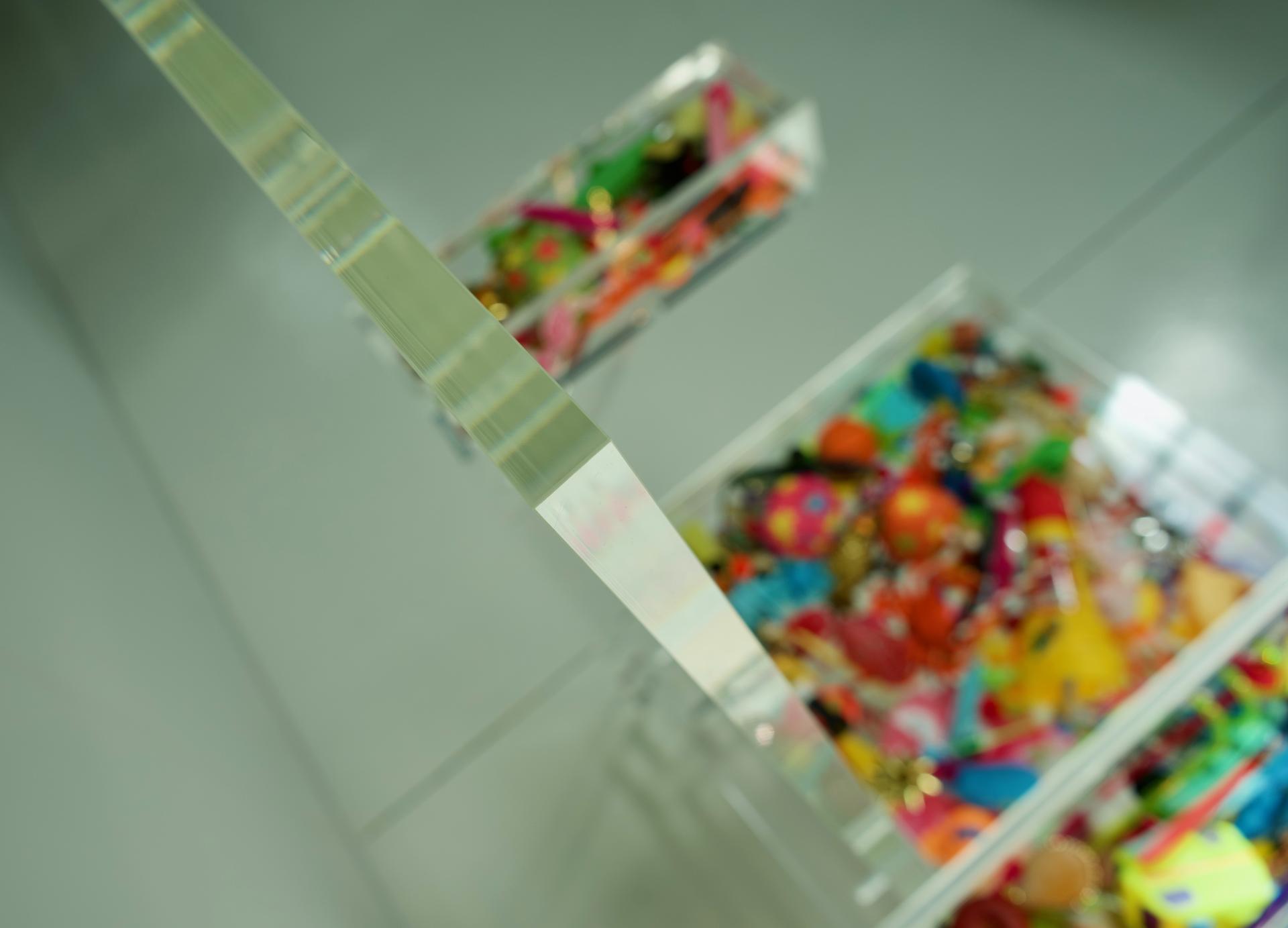 Transparent acrylic furniture with colorful decorative items, showcasing the intersection of design and creativity in Ruud van Eijk's work.