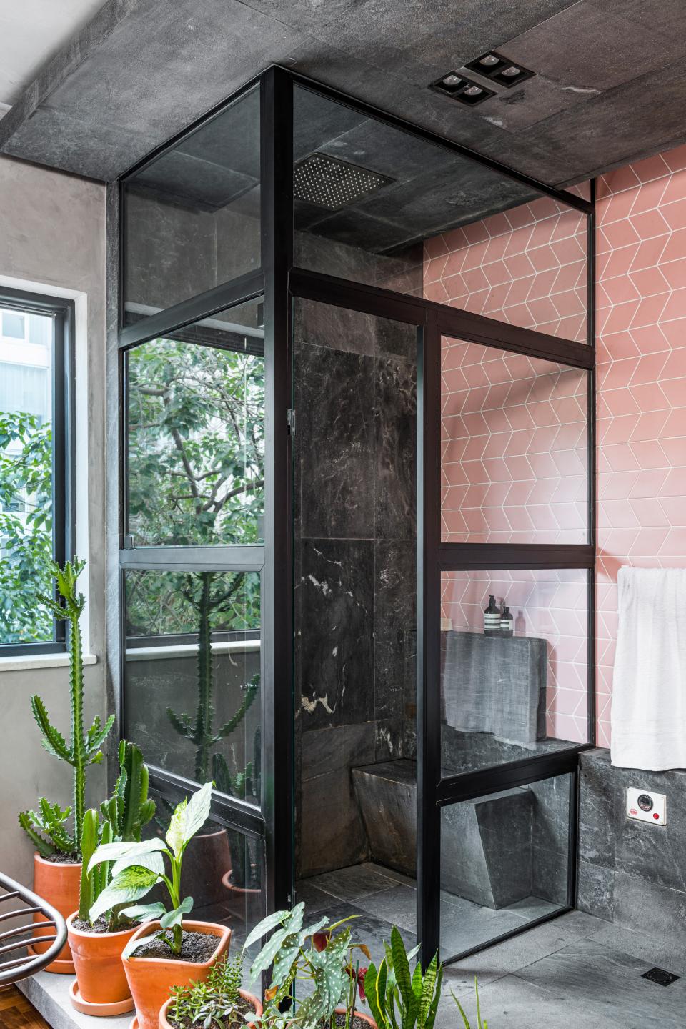 Modern bathroom design featuring glass shower enclosure, patterned tiles, and indoor plants, highlighting a connection with nature.