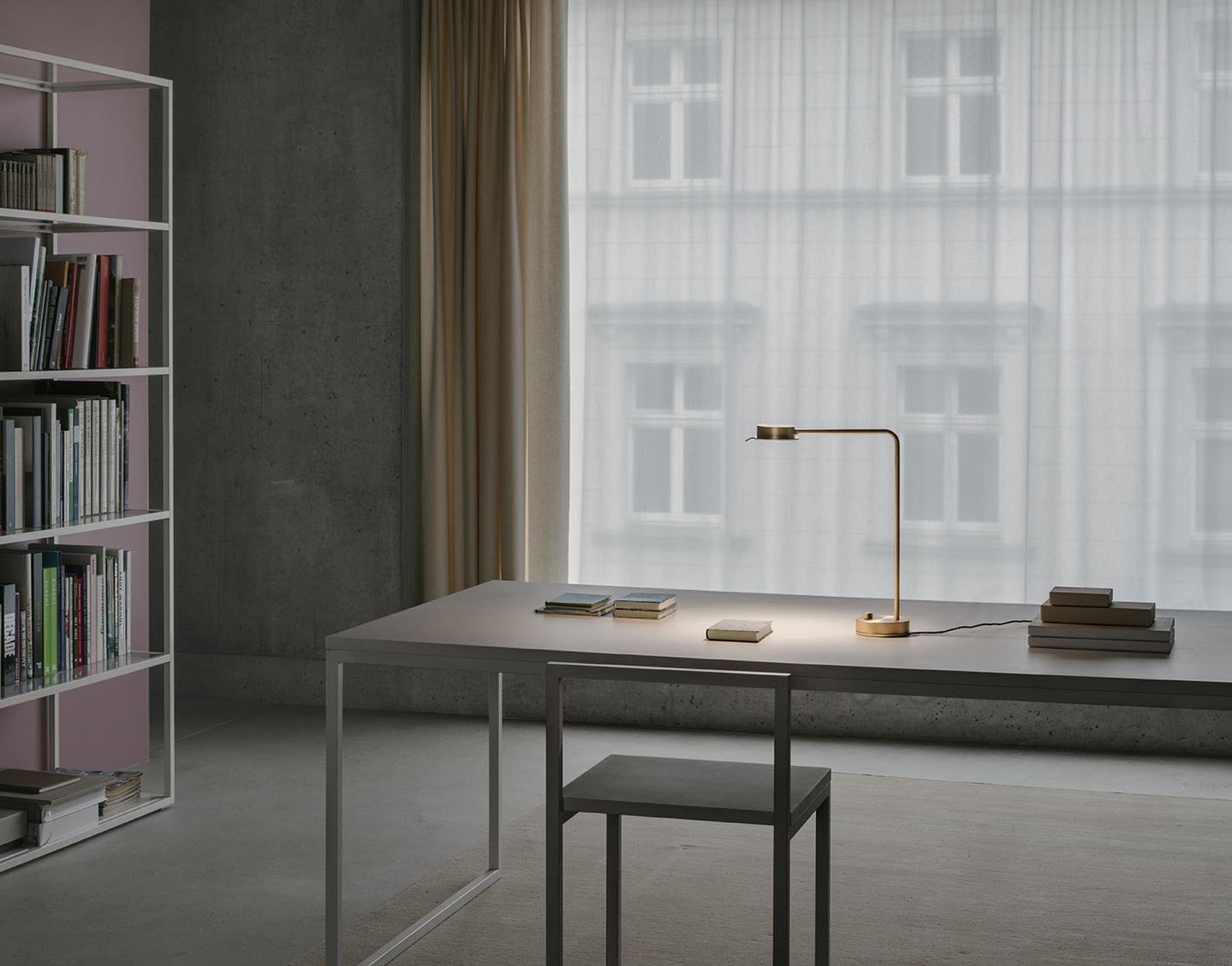Elegant w102 Chipperfield lamp by Wästberg on a minimalist desk surrounded by books, enhancing modern interior design.