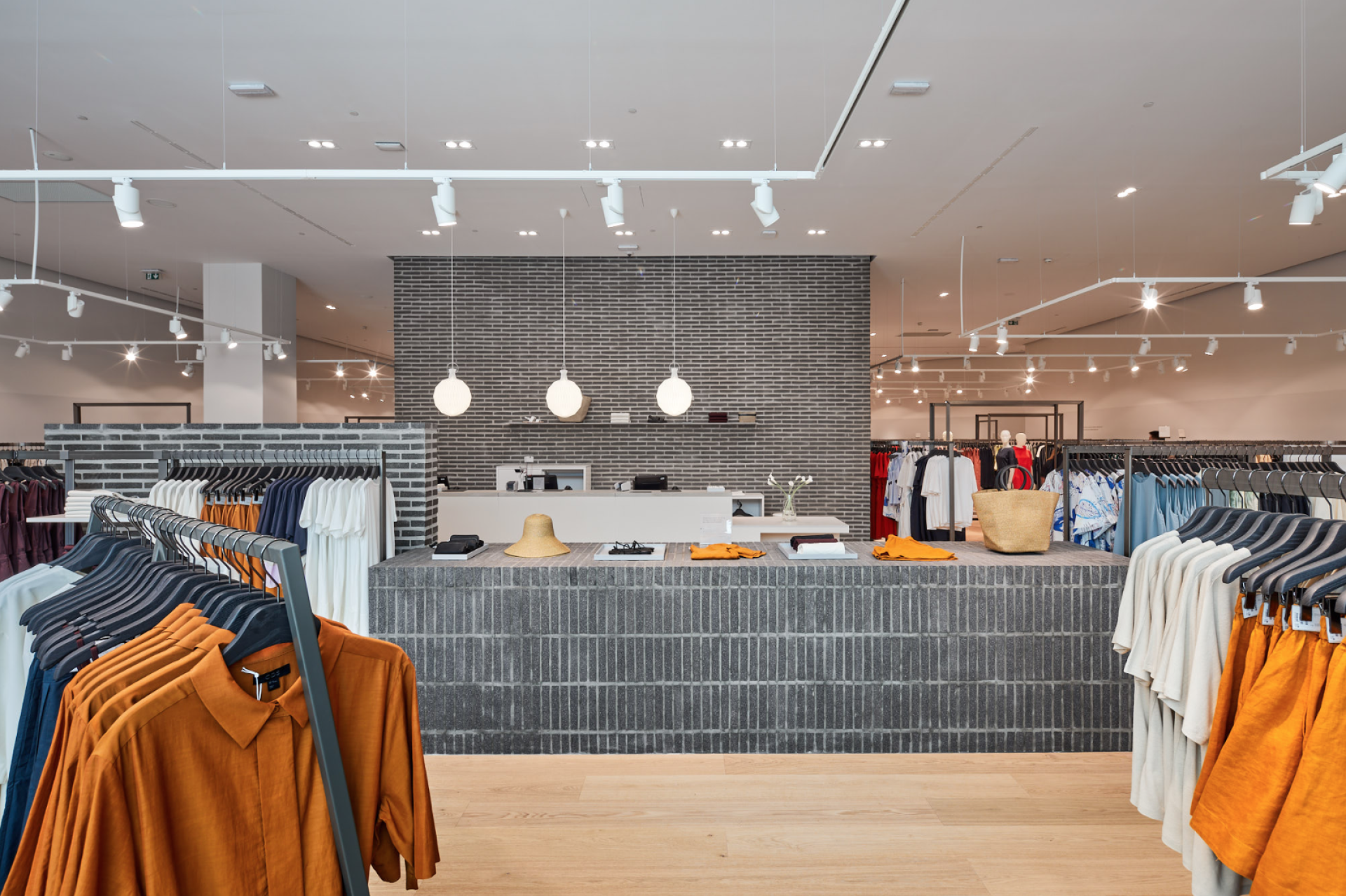 Modern retail space with sustainable design, featuring eco-friendly materials and a variety of clothing on display.