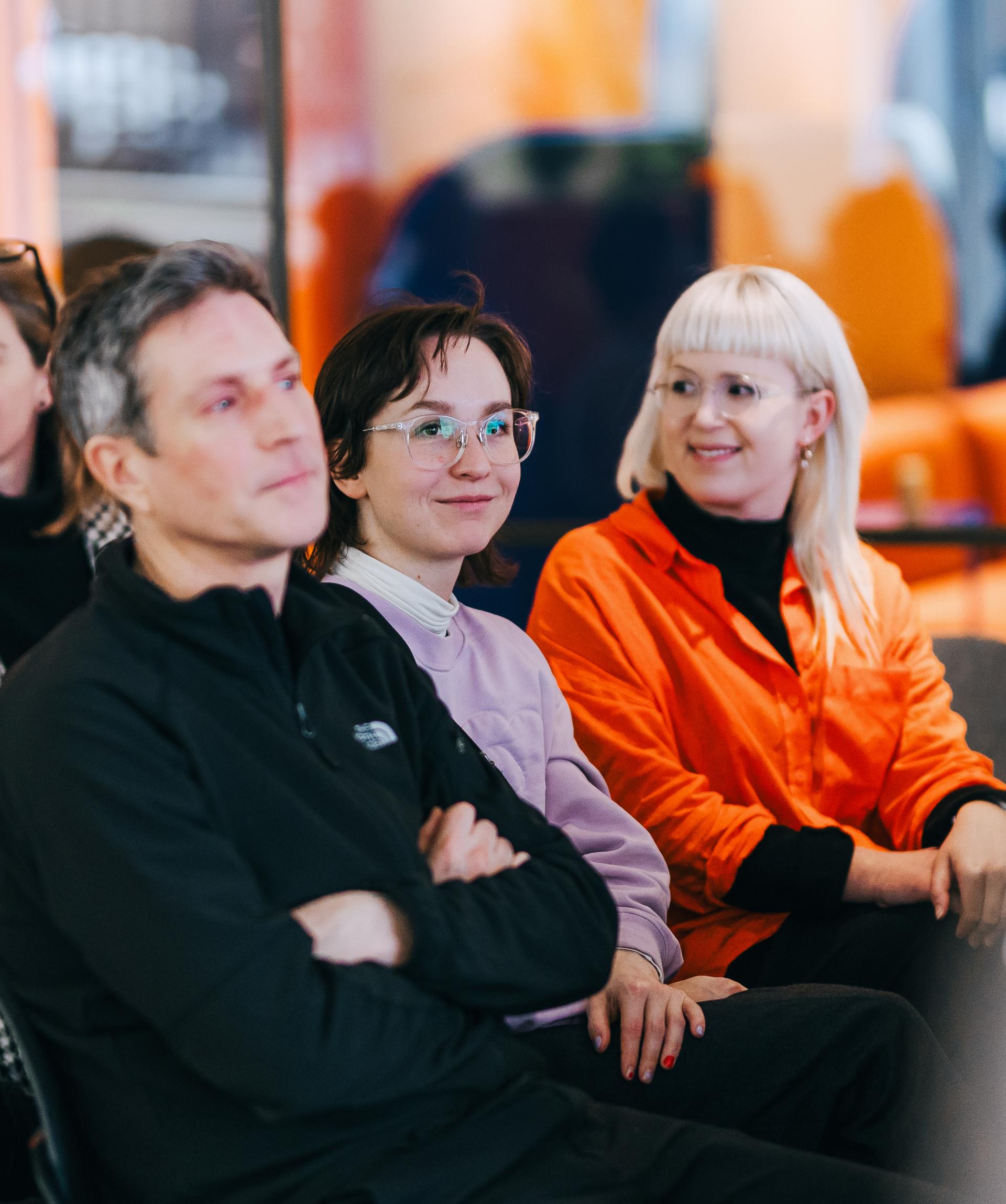 Audience members engaged during a discussion on sustainable solutions at the University of Glasgow, featuring diverse expressions and attire.