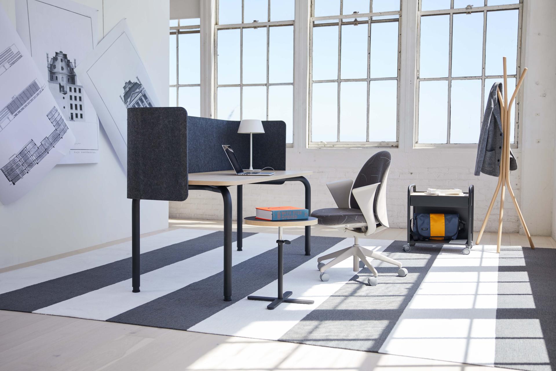 Modern workspace featuring Pearson Lloyd's Routes furniture, including a desk, ergonomic chair, and stylish side table.