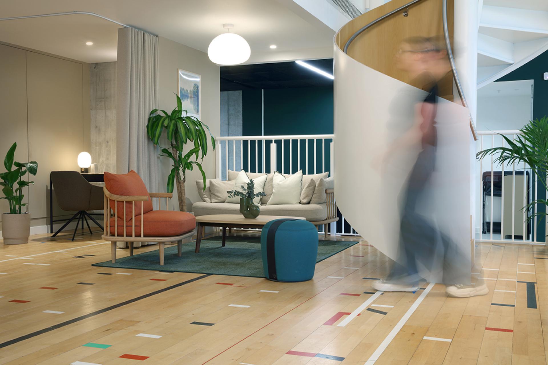 Stylish social hub at Eden, New Bailey features modern furniture, vibrant decor, and a spiral staircase for community interaction.