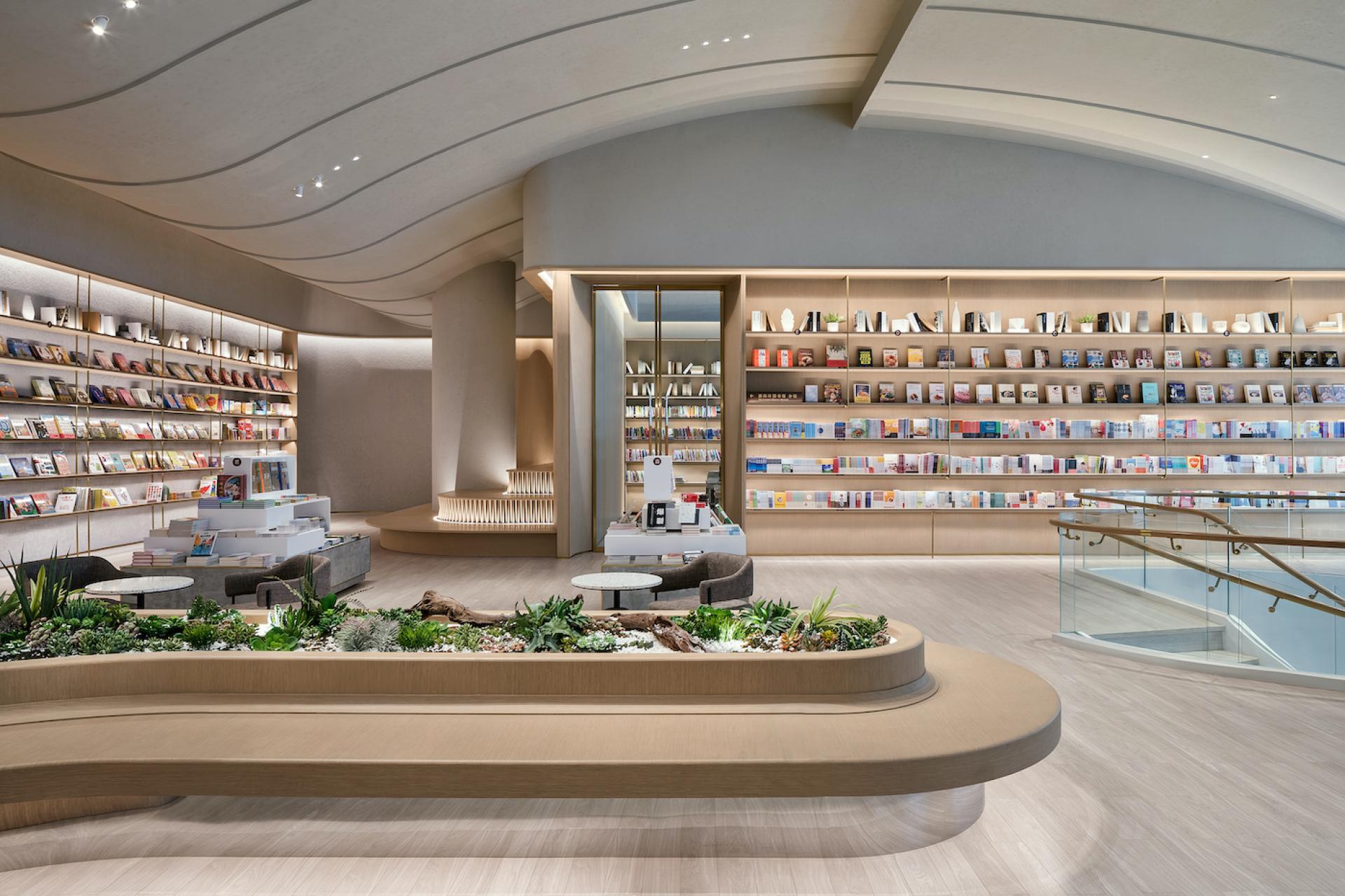 Modern bookshop interior by Karv One featuring curved architecture, inviting seating areas, and extensive shelves filled with books.