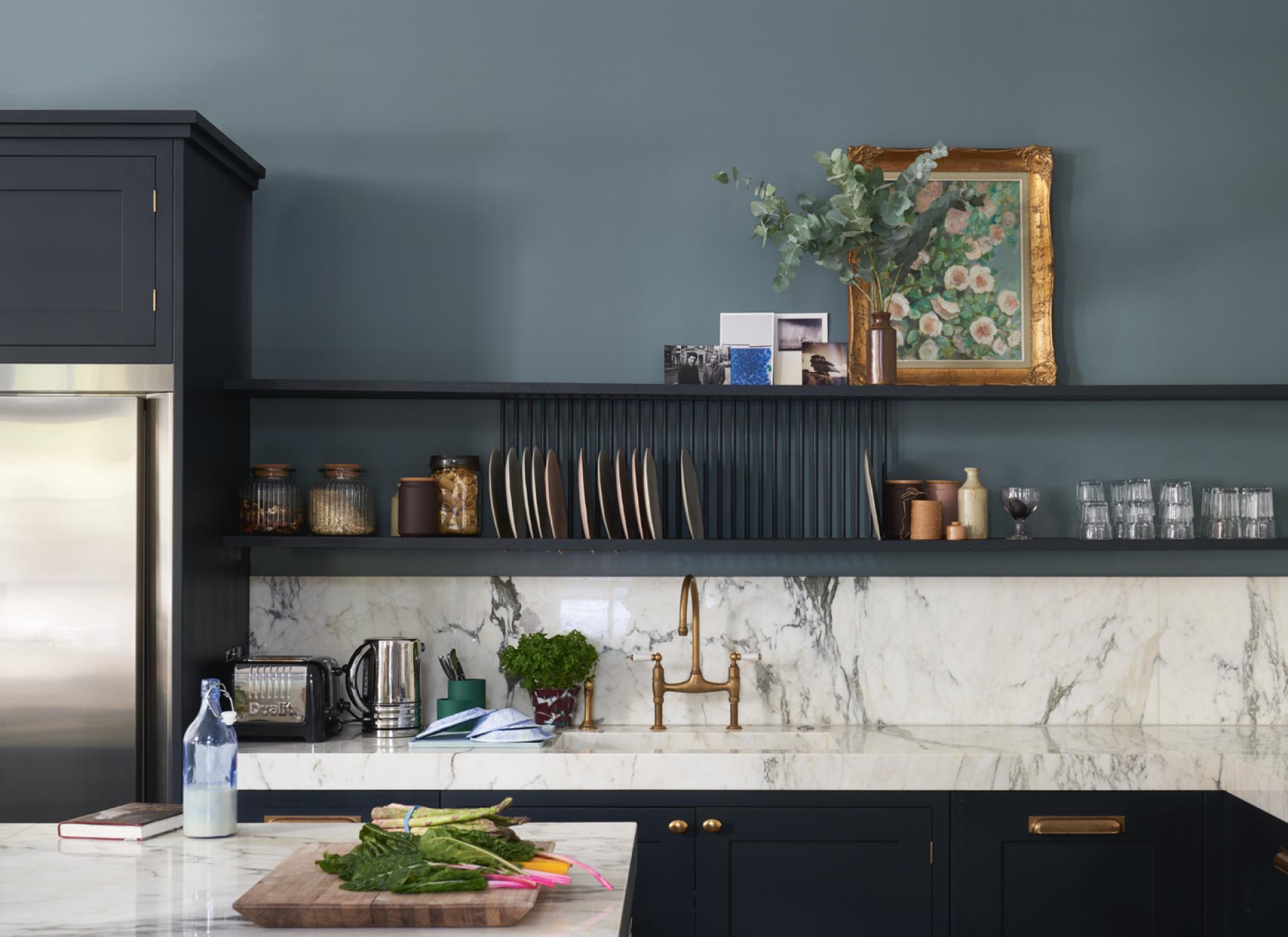 Modern kitchen featuring Farrow & Ball's bold colors, marble countertops, and stylish decor elements with fresh vegetables.