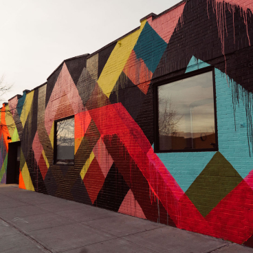 Vibrant urban mural featuring geometric patterns in bold colors, celebrating MINI's electric vehicle launch.