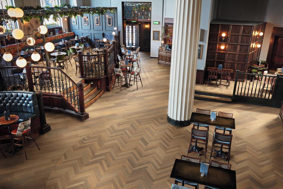 Stylish interior featuring Karndean Designflooring's Art Select wood collection, showcasing herringbone patterns in a vibrant dining space.
