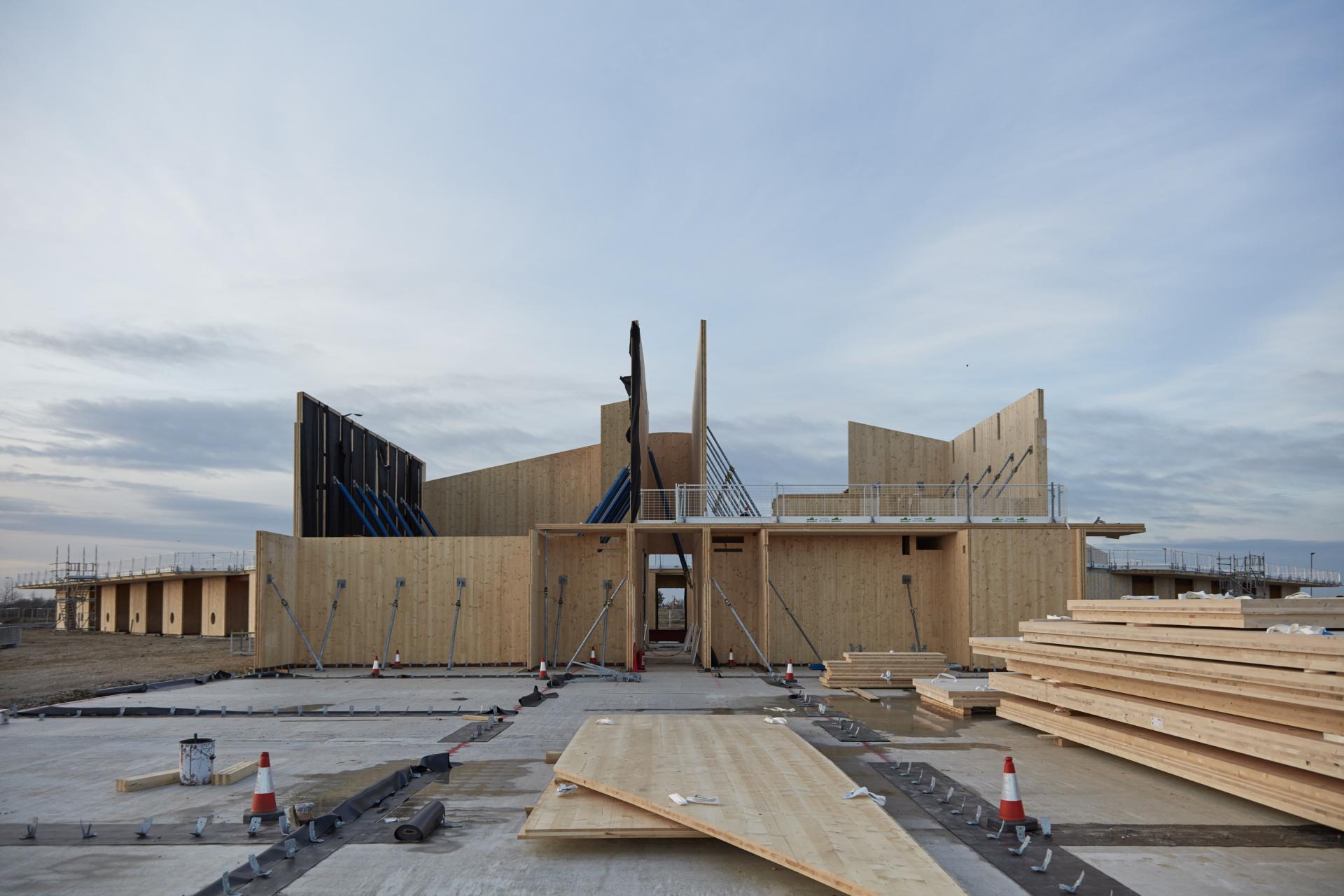 Cross Laminated Timber construction site showcasing wood panels and modern architectural design under a cloudy sky.