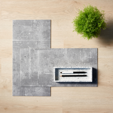 Tarkett's modular resilient flooring samples displayed with a green plant and minimalist stationery, highlighting sustainability in design.