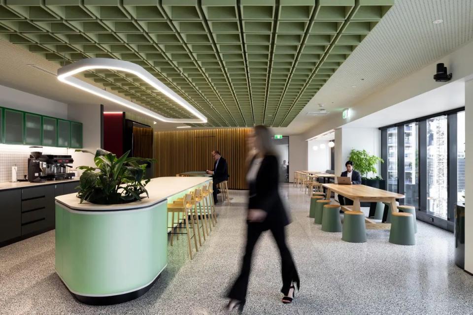 Sculptural acoustic ceiling tiles in a modern office space, featuring greenery and stylish furniture for enhanced aesthetics.