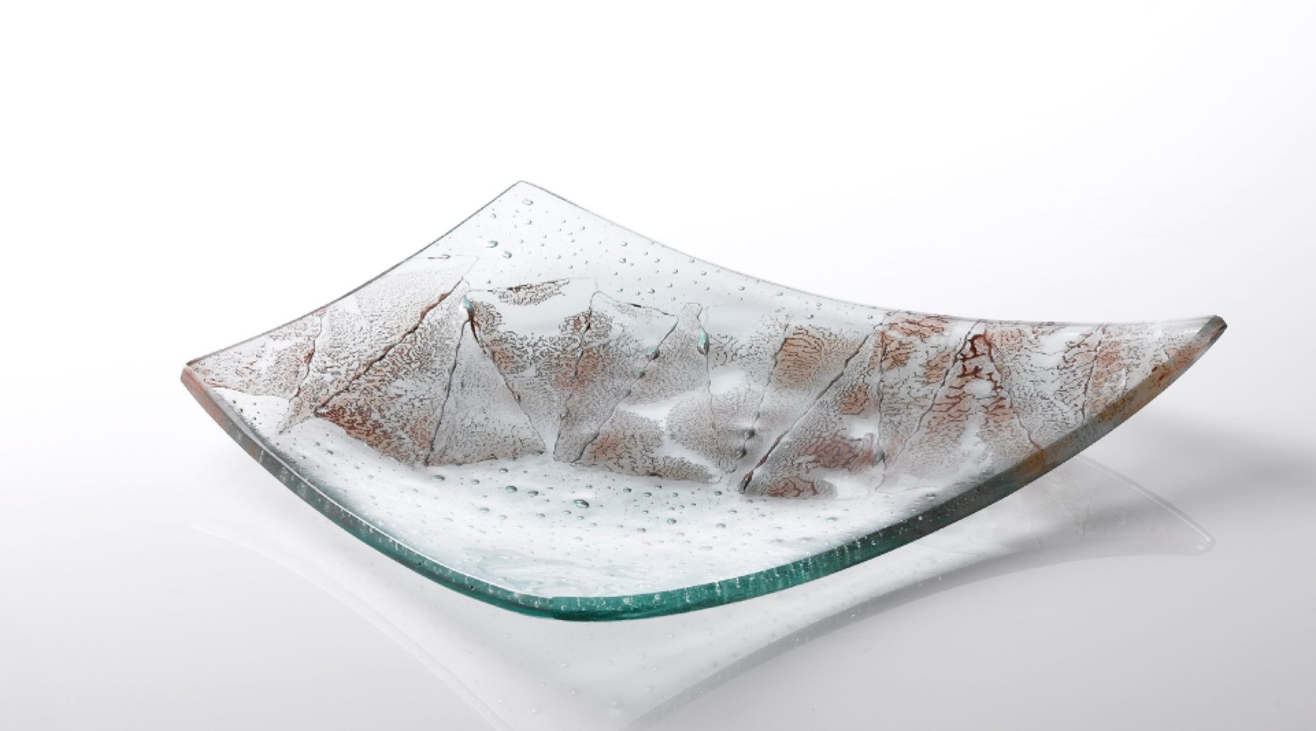 Sculptural glass dish with textured surface, showcasing contemporary craft and design from Manchester's vibrant artistic scene.