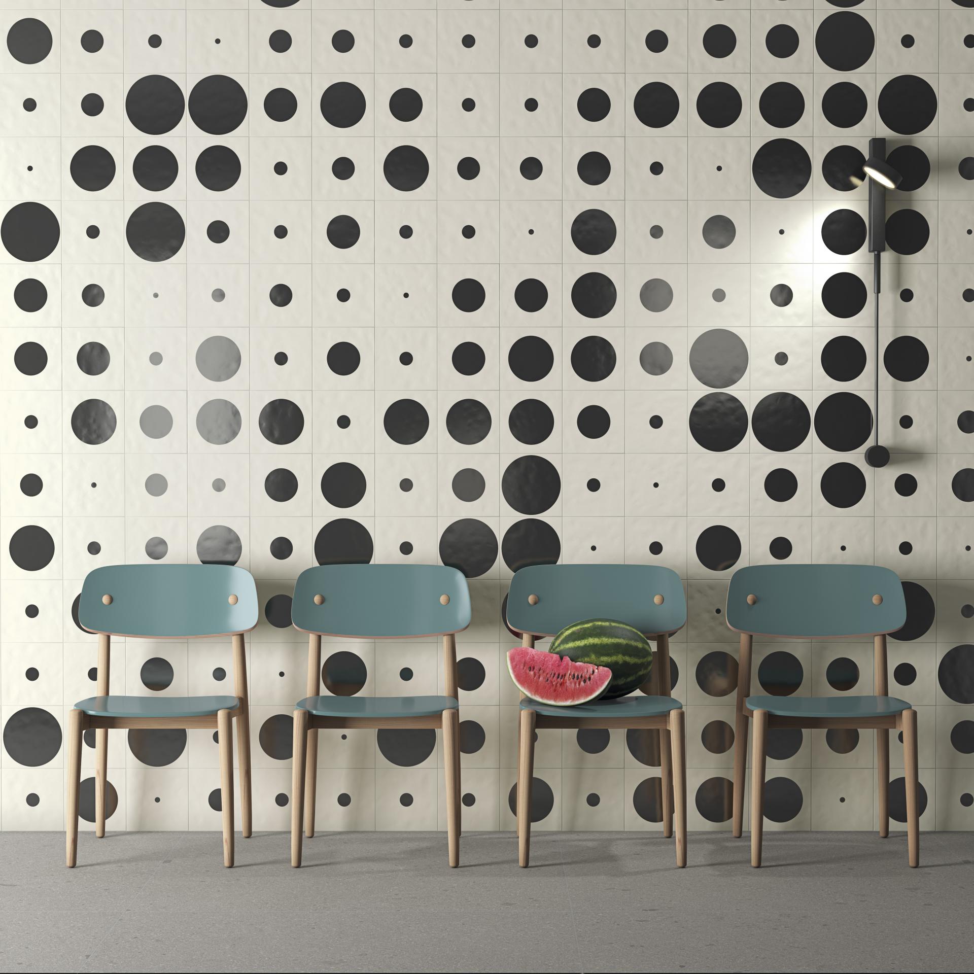 Ceramic wall tiles with bold black and white polka dots complement teal wooden chairs and a slice of watermelon.