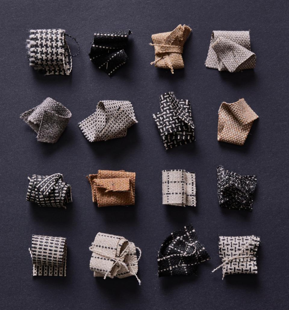 Collection of sustainable mini fabric samples in monochrome patterns by Camira, displayed on a dark background.