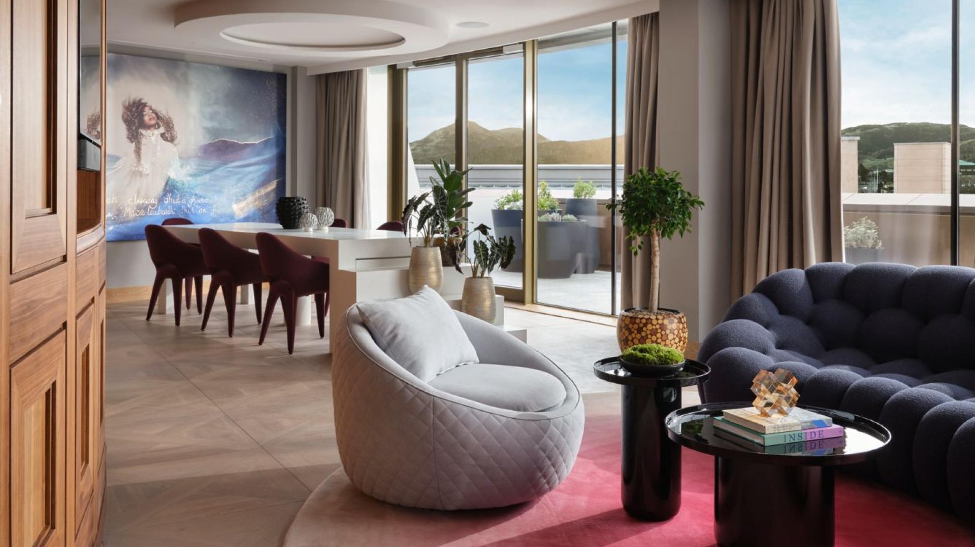 Stylish interior of the W Hotel Edinburgh featuring modern furniture, vibrant décor, and botanical elements with views of the city.