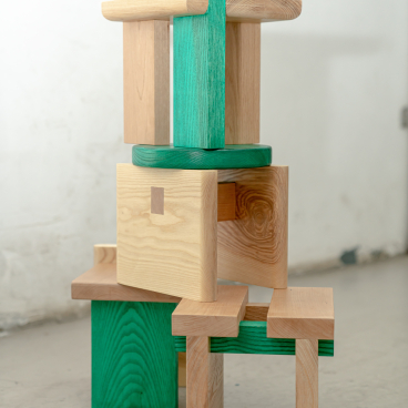 Colorful wooden mini-stools stacked creatively, showcasing versatile design and craftsmanship by Napp Studio for adaptable furniture solutions.