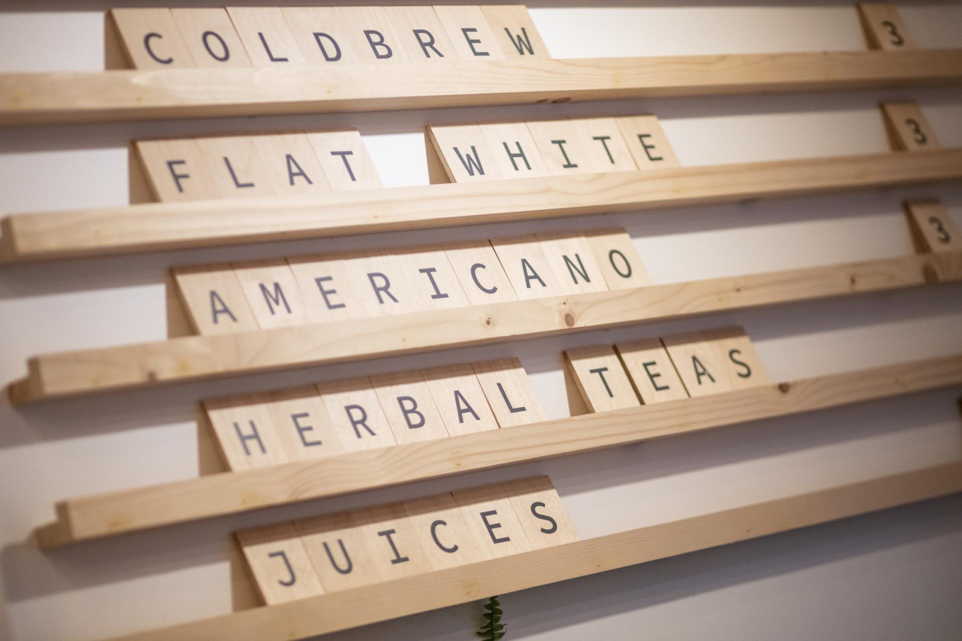 Menu board with wooden letters displaying drink options, including cold brew, flat white, and herbal teas at Brew 204 Dublin.
