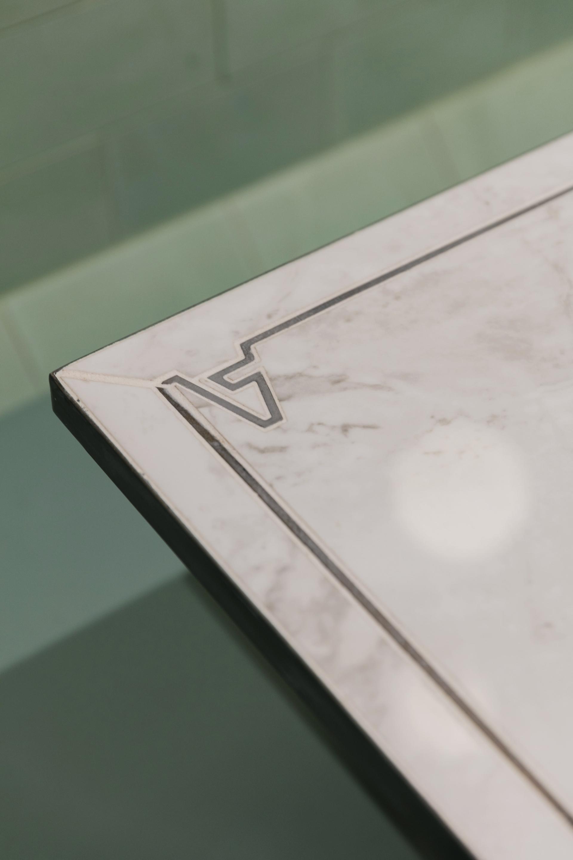 Elegant marble table edge with Art Deco design, featured in Lina Stores' Italian restaurant interiors in Soho.
