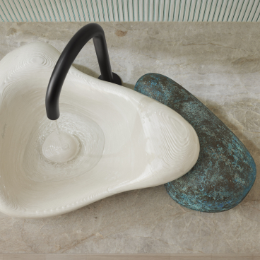 Elegant 3D-printed sink by Kohler and Daniel Arsham, featuring a unique design with black faucet and textured surface.