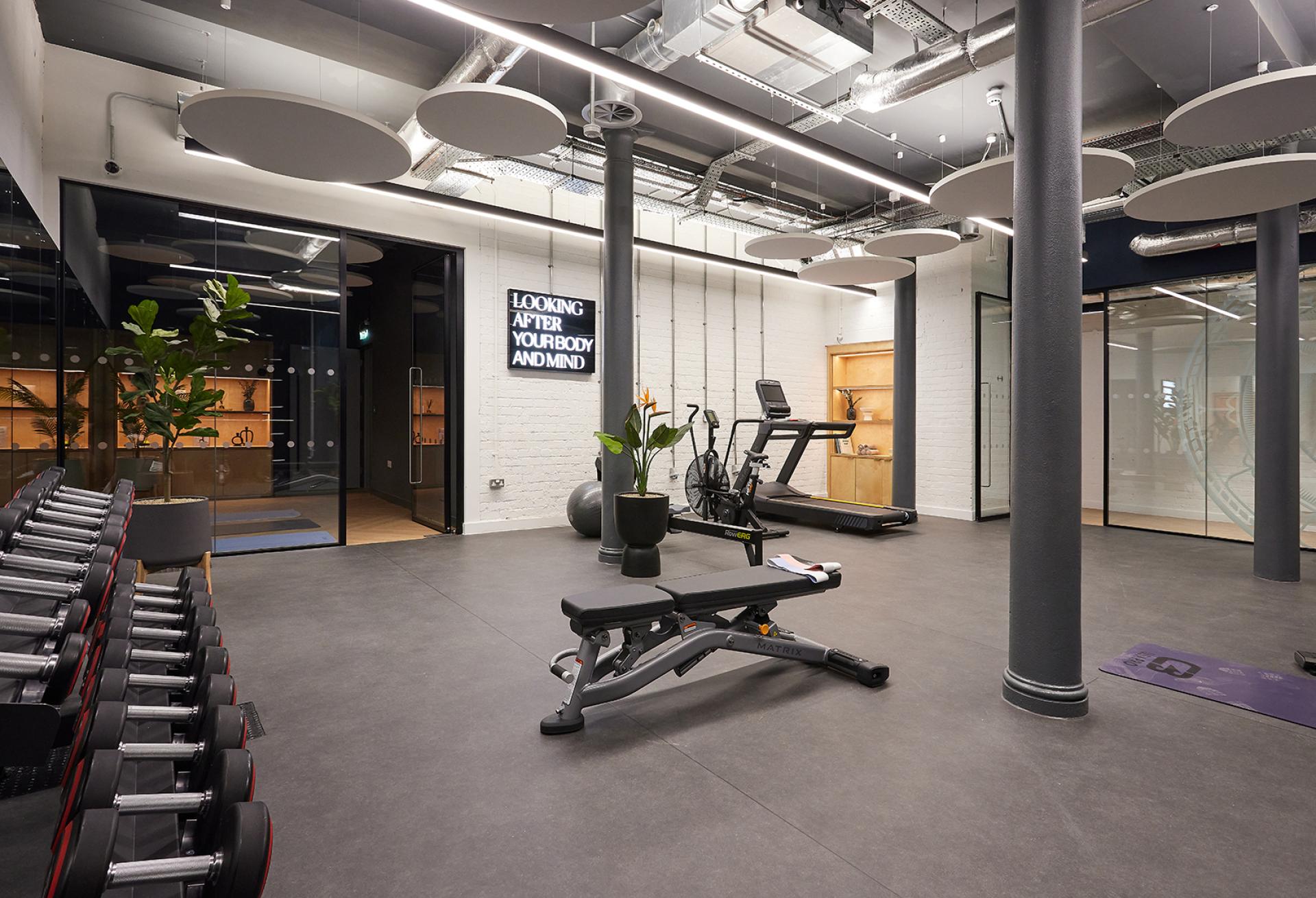 Modern gym interior of Michael Laird Architects' Manchester office, featuring workout equipment and wellness-focused design elements.