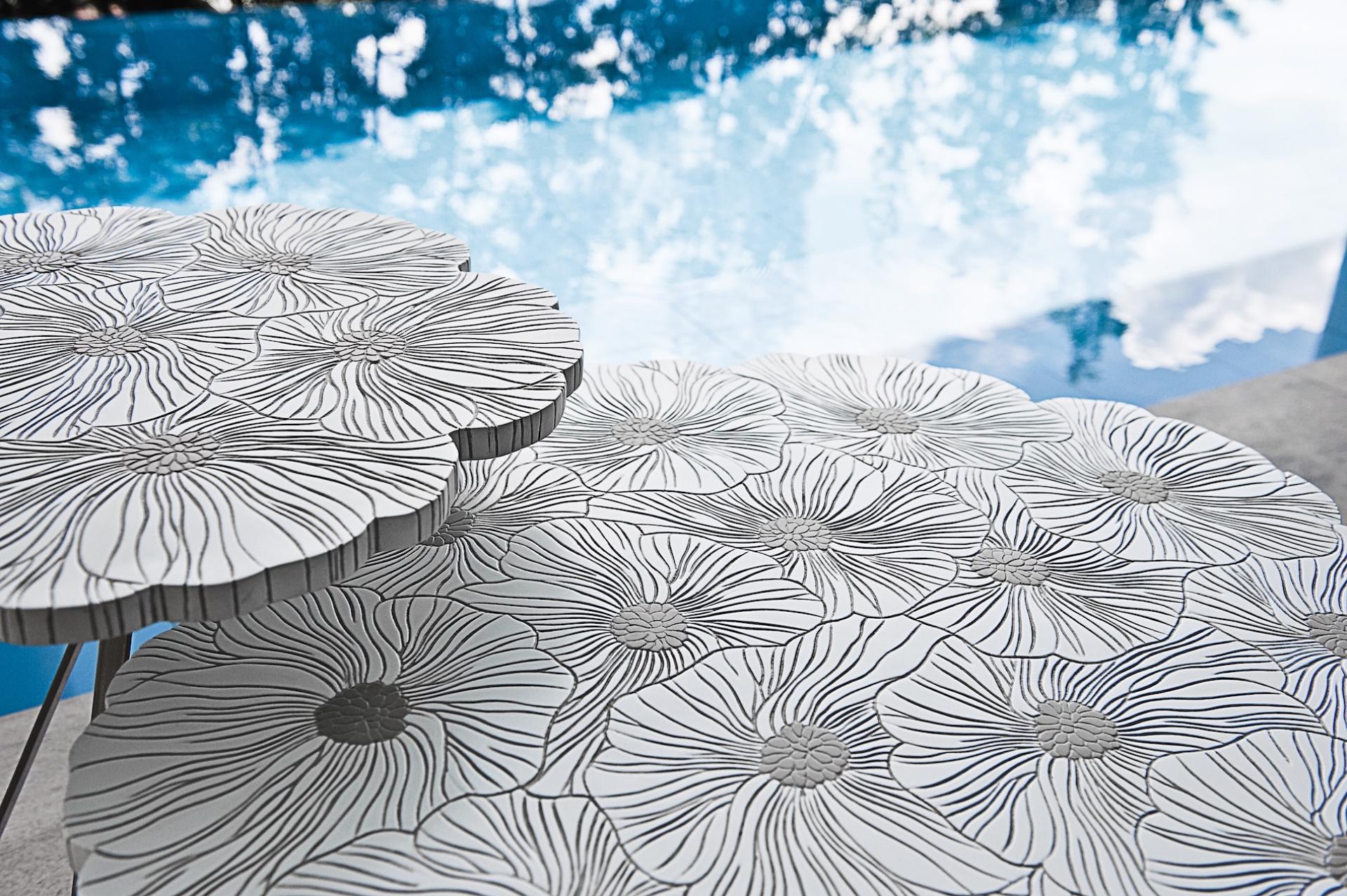 Stylish table features floral patterns, reflecting Kenneth Cobonpue's celebration of spring's delicacy and vivacity by a pool.