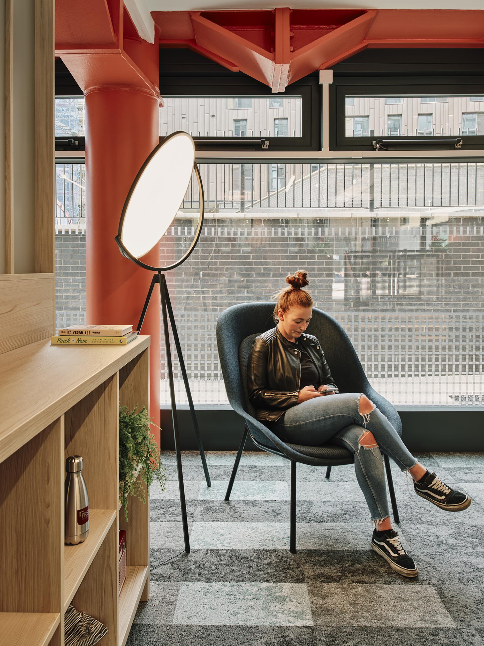 Stylish student relaxing in modern lounge at The Refinery, showcasing innovative design and comfortable amenities in Leeds.