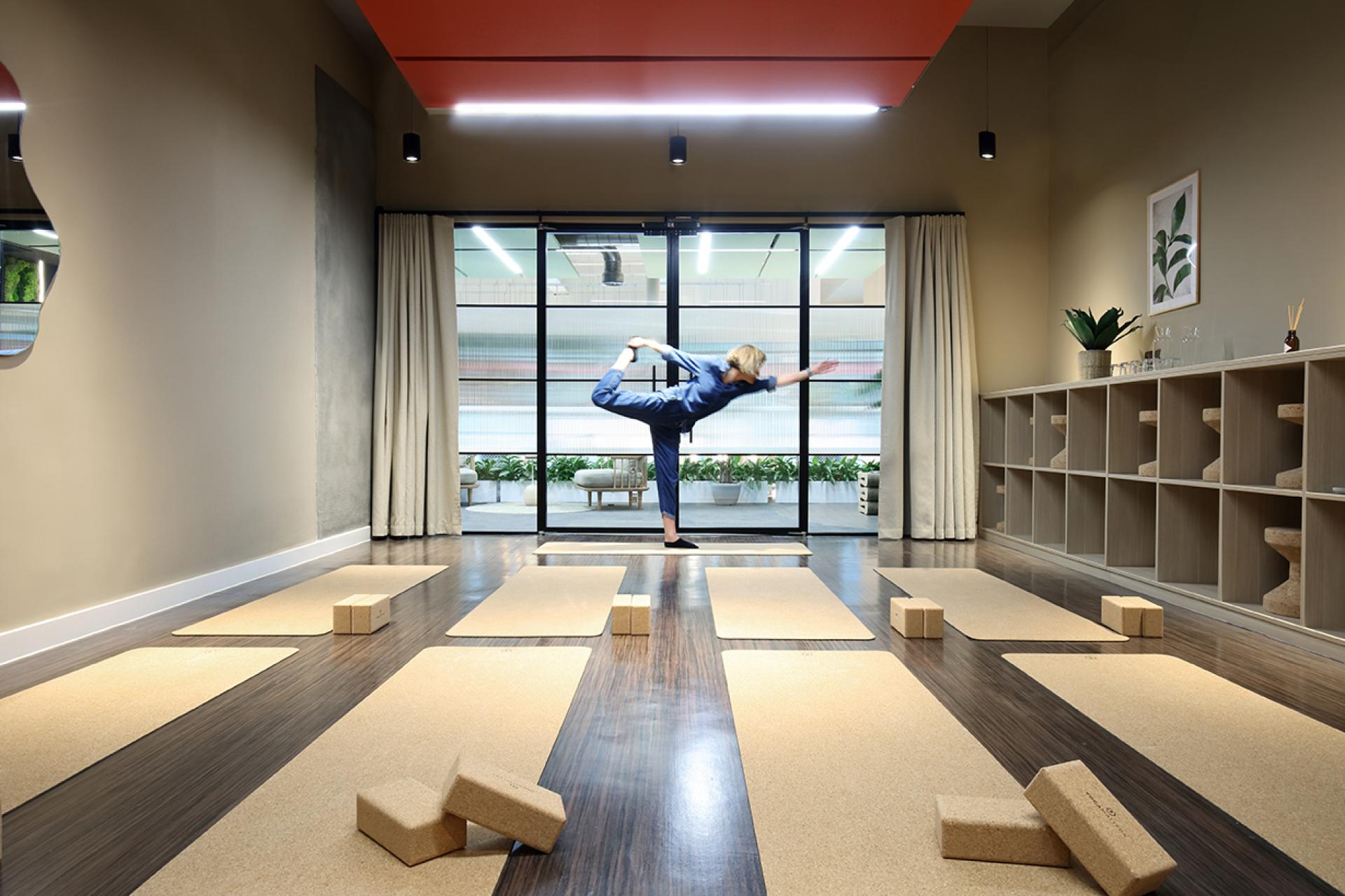 Yoga practice in a sustainable community hub at Eden, New Bailey, featuring exercise mats and natural decor.