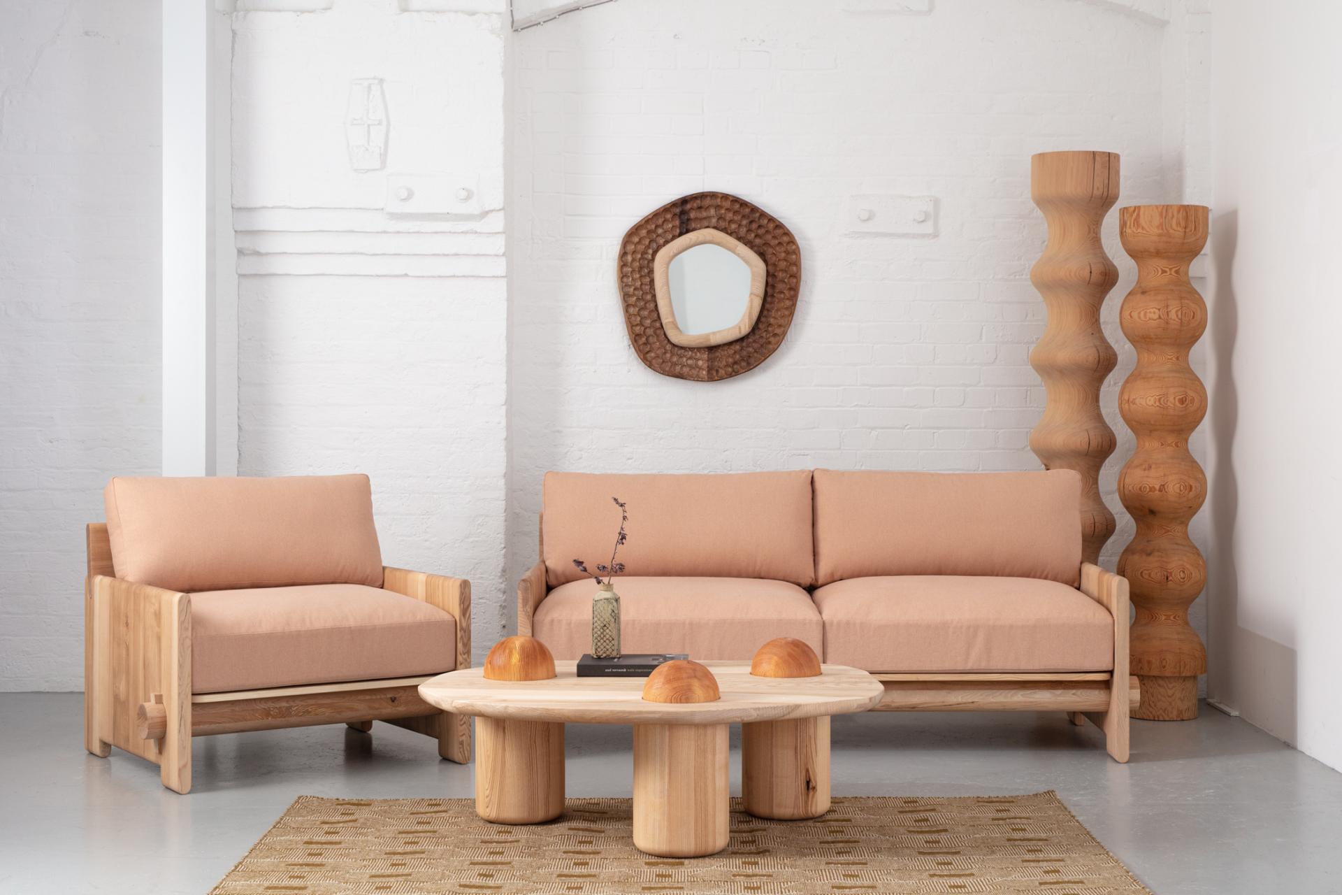 Stylish wooden furniture by Jan Hendzel, featuring a sofa, chairs, and a unique coffee table in a modern setting.