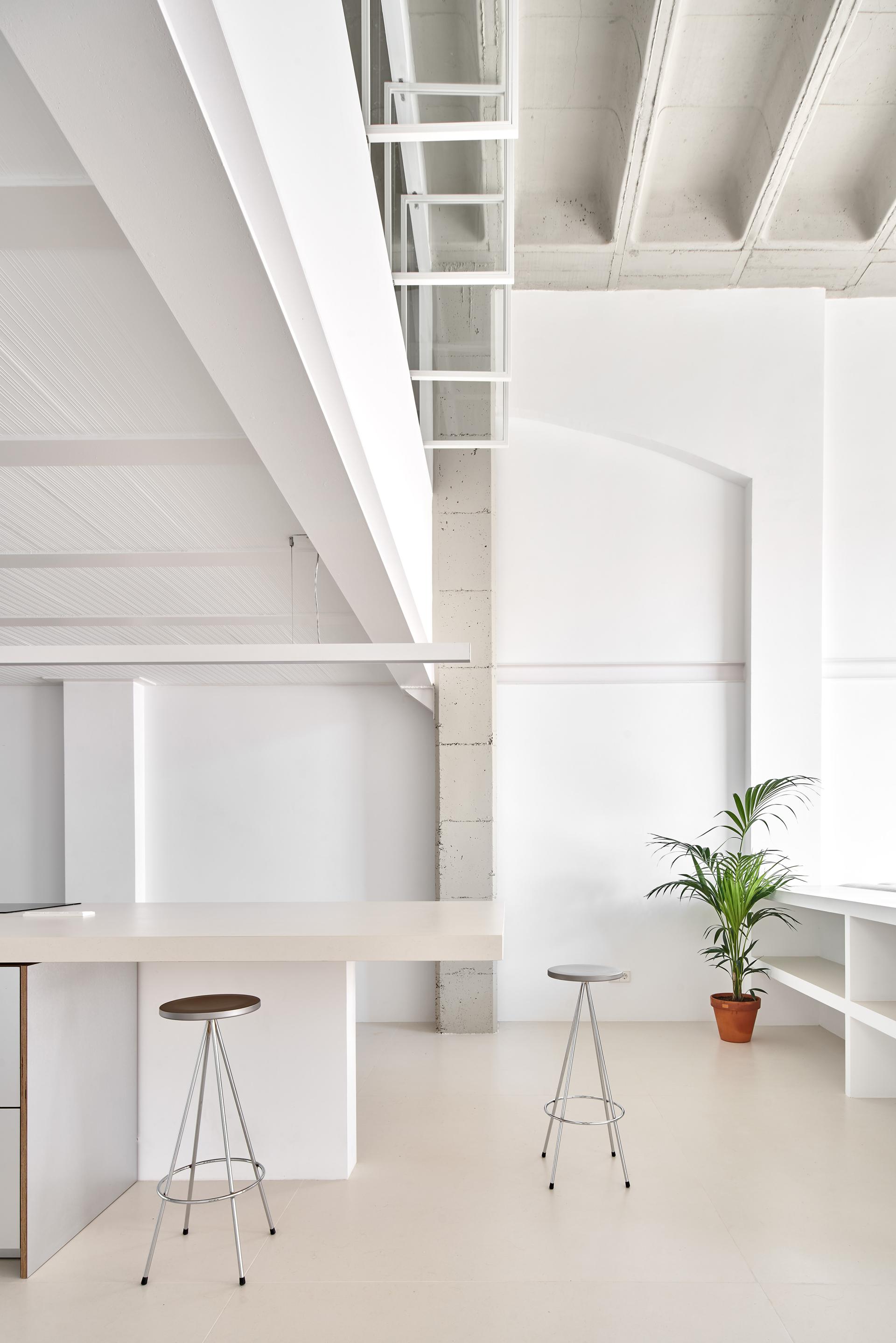 Modern interior featuring sleek ceramic surfaces, minimalist design elements, and greenery, showcasing innovative uses of Spanish ceramics.