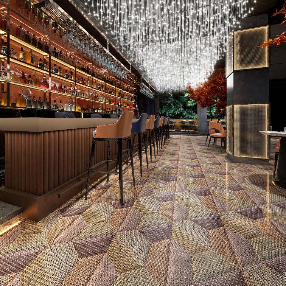 Stylish bar interior featuring Mac Stopa's geometric flooring design, illuminated by striking overhead lighting.