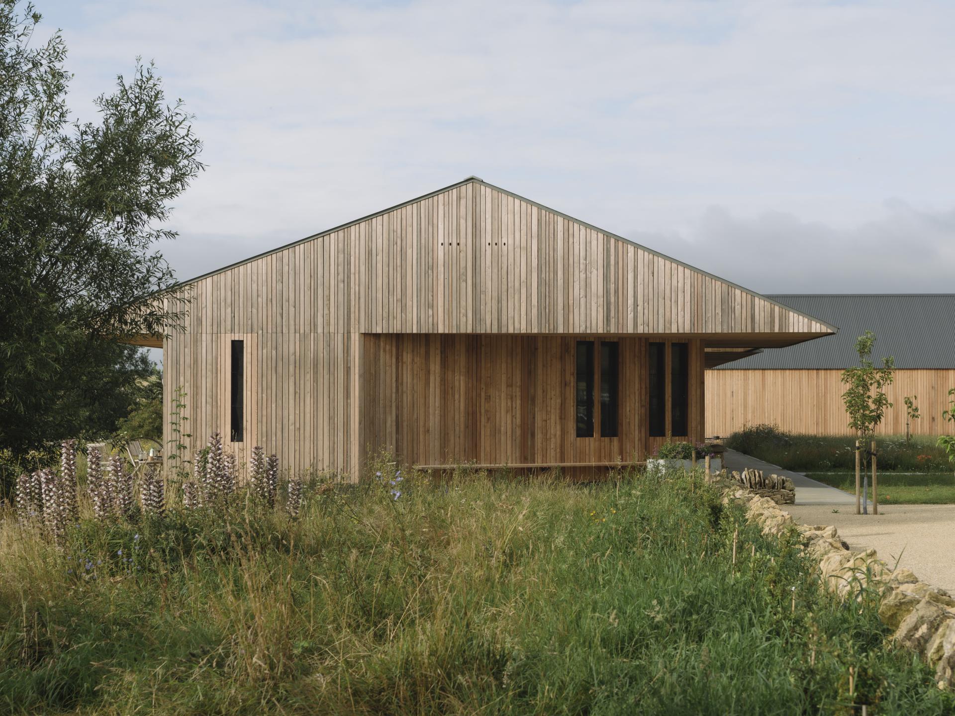 Sustainable education centre featuring modern wooden architecture set within lush, natural surroundings in the Cotswolds.