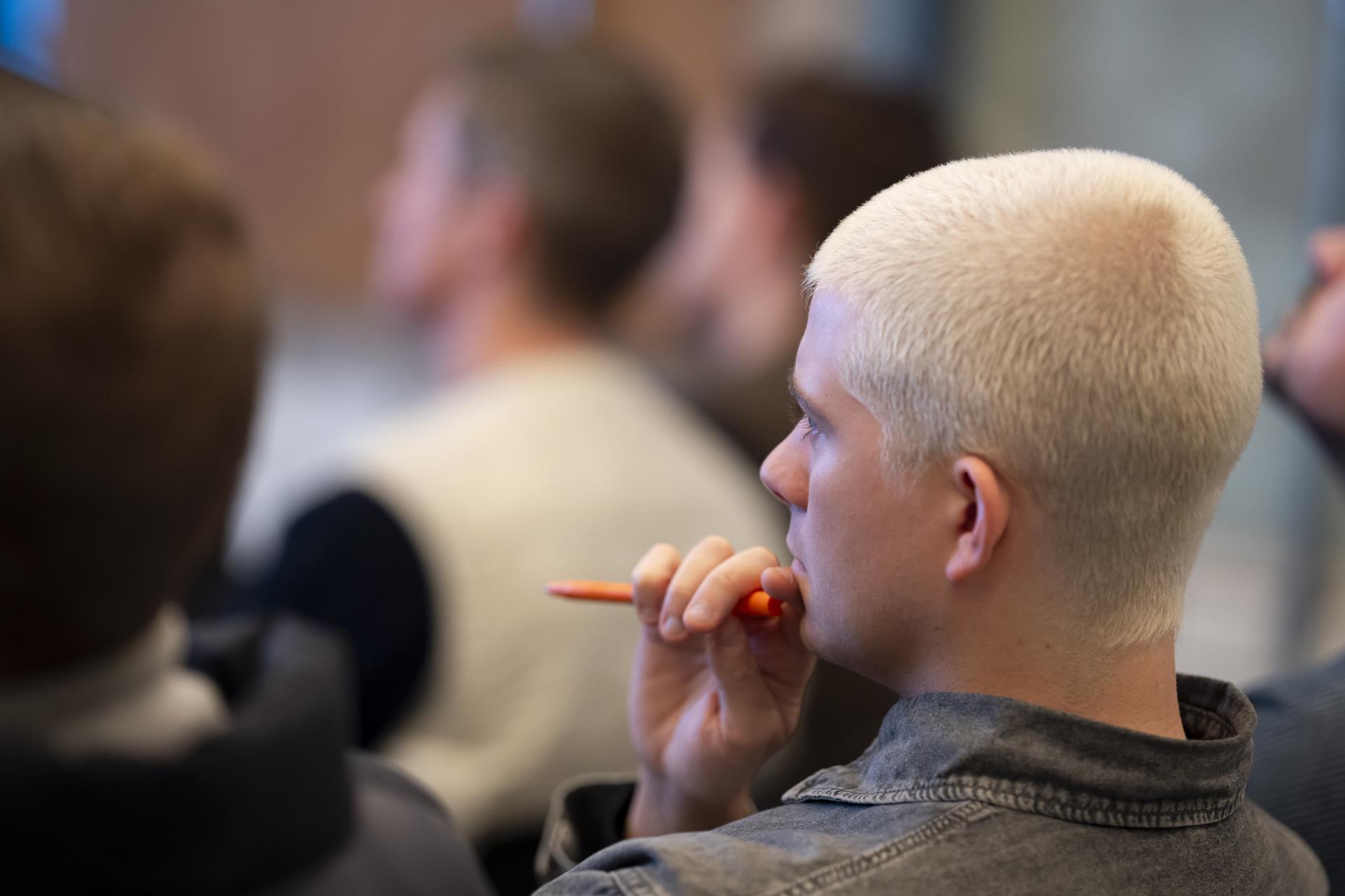 Engaged audience member listening to a talk about graphene innovations at the Graphene Engineering Innovation Centre in Manchester.