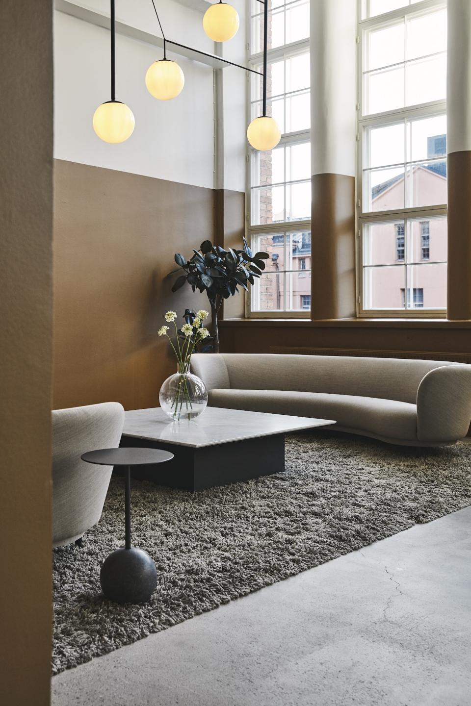 Stylish lounge area in a refurbished bread factory featuring modern furniture and ample natural light.