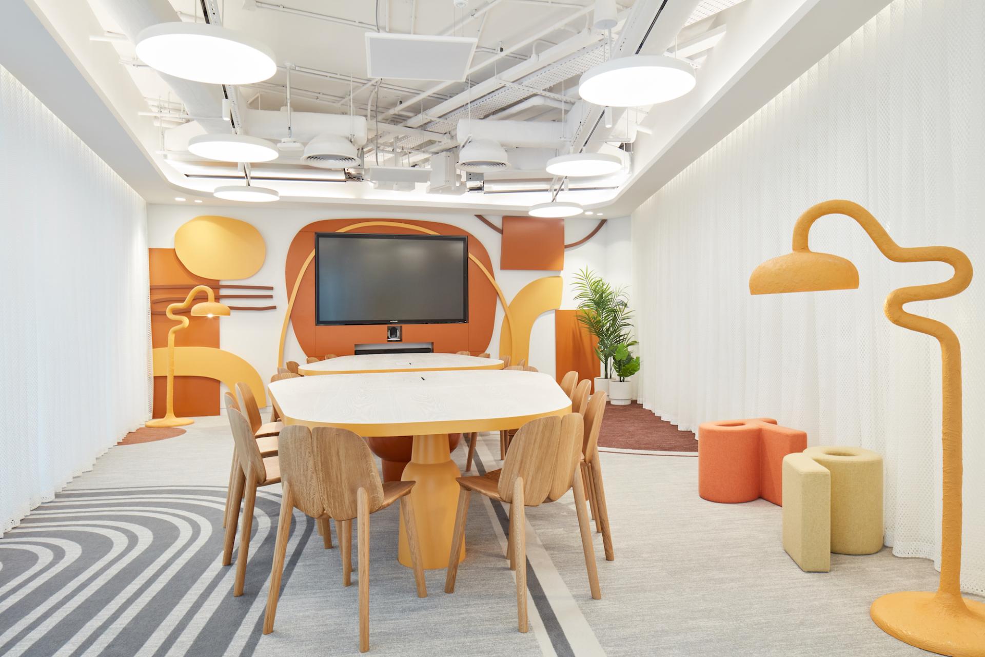 Brightly colored meeting room designed by Roar Studio, featuring playful furniture and dynamic wall art for the Early Childhood Authority HQ.
