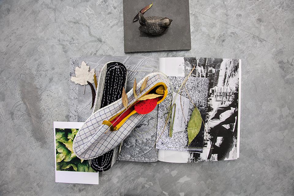 Colourful textile samples, prints, and natural elements arranged artistically on a textured surface, embodying Kvadrat's design philosophy.