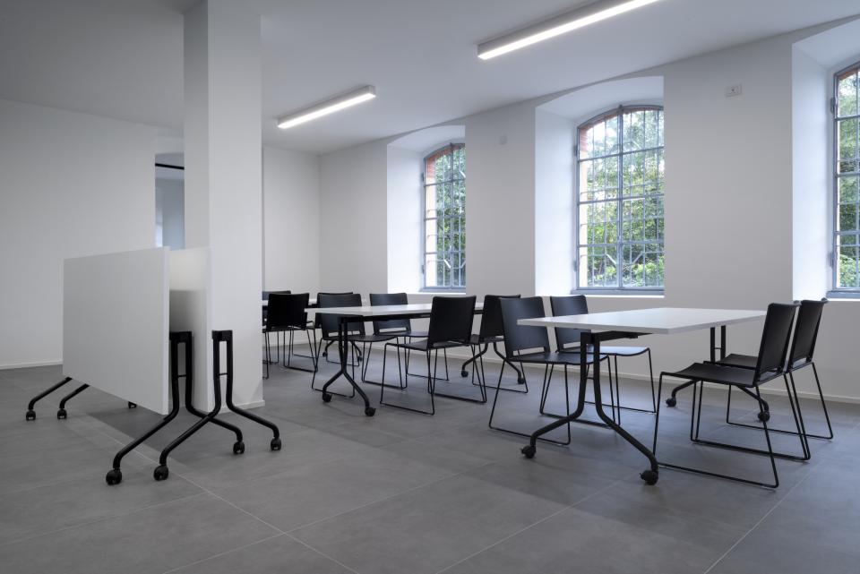 Modern office space at T&T's new headquarters featuring minimalist design, movable tables, and ample natural light from large windows.