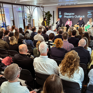Engaged audience at the Glasgow Property Outlook event, discussing trends in the real estate market.