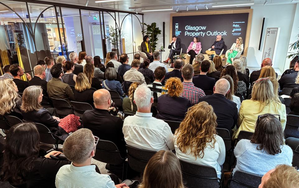 Engaged audience at the Glasgow Property Outlook event, discussing trends in the real estate market.