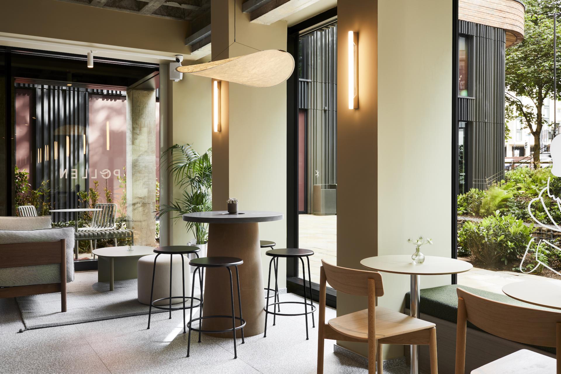 Modern café interior at Pollen Bakery featuring stylish furniture, greenery, and natural light, celebrating quality and heritage.