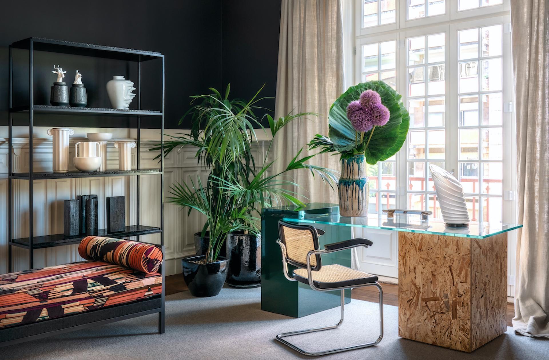 Luxurious furniture display featuring Cristina Jorge de Carvalho’s designs, including an elegant desk, shelving, and decorative plants.